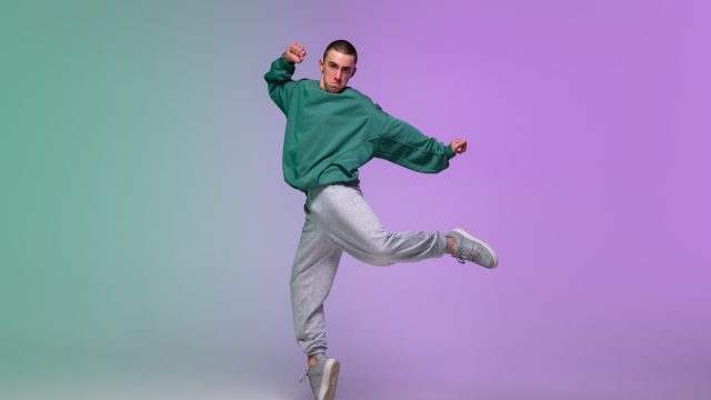 グラデーションの背景とヒップホップダンスを踊る男性